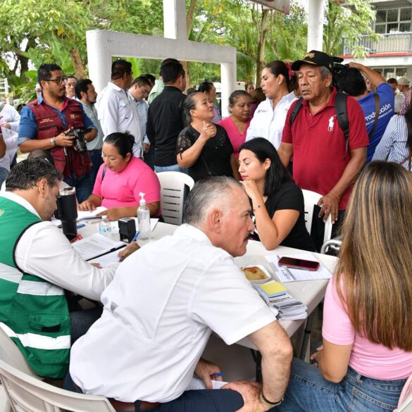 Javier May atiende a ciudadanos durante jornada de servicios en Huimanguillo con funcionarios y pobladores reunidos alrededor de mesas de atención.