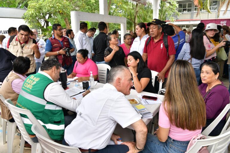 Javier May atiende a ciudadanos durante jornada de servicios en Huimanguillo con funcionarios y pobladores reunidos alrededor de mesas de atención.