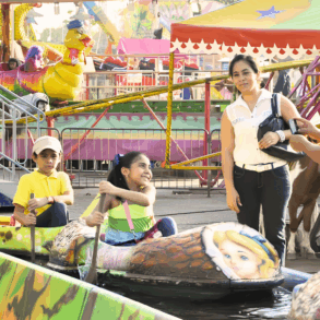 Niños disfrutando de los juegos mecánicos en el Parque Tabasco bajo el nuevo horario nocturno.