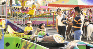 Niños disfrutando de los juegos mecánicos en el Parque Tabasco bajo el nuevo horario nocturno.