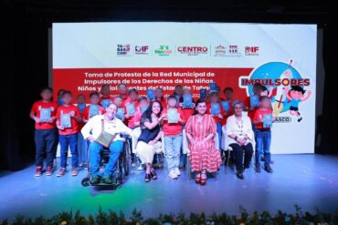 Niñas, niños y adolescentes de la red infantil en el escenario con autoridades