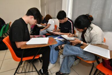 Estudiantes universitarios realizan ejercicios académicos en aula durante proceso de preparación académica