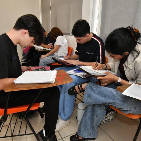 Estudiantes universitarios realizan ejercicios académicos en aula durante proceso de preparación académica