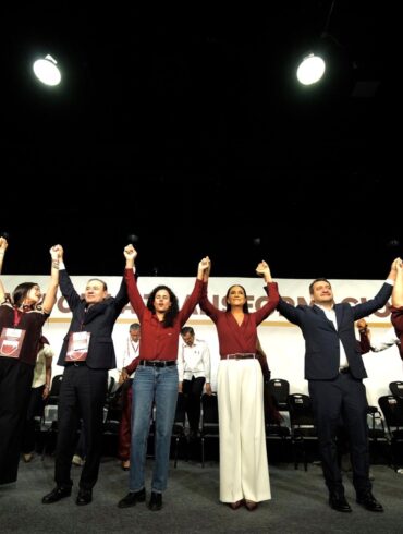 Ariadna Montiel al centro del escenario junto a líderes de Morena con los brazos en alto durante el VIII Congreso Nacional Extraordinario, celebrado el 3 de mayo de 2026 en el World Trade Center de la Ciudad de México