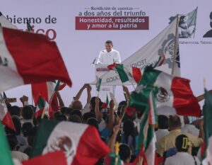 Gobernador Javier May Rodríguez en el podio de la rendición de cuentas de Claudia Sheinbaum en Plaza de Armas de Villahermosa, rodeado de banderas mexicanas