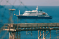 El crucero MV Hondius fondeado frente al puerto industrial de Granadilla en Tenerife, visto a través del alambrado del perímetro de seguridad sanitaria, este sábado previo al desembarco internacional.