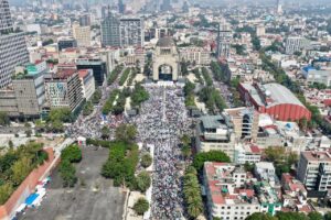 Revisando las seis imágenes con criterio editorial. SELECCIÓN Y ARQUITECTURA FOTOGRÁFICA Decisión de distribución: No galería. Las fotos trabajan mejor dispersas a lo largo del texto porque cada una ilustra un momento narrativo distinto — la multitud, el discurso, el contacto humano. Una galería las aplana todas al mismo nivel y compite con las tablas de datos. La distribución individual refuerza el ritmo del artículo. FOTO PRINCIPAL — Imagen 5 (aérea lejana, Monumento al fondo) La más poderosa para abrir. Muestra la magnitud completa del mitin con el Monumento a la Revolución reconocible al fondo y la avenida desbordada de gente. Es la foto que responde visualmente al lead: decenas de miles. Composición limpia, luz natural, contexto urbano identificable. SEO filename: sheinbaum-monumento-revolucion-mitin-soberania-1-junio-2025 Alt text: Vista aérea del mitin convocado por la presidenta Claudia Sheinbaum en el Monumento a la Revolución el 1 de junio de 2025, con miles de simpatizantes desbordando la explanada y las avenidas aledañas