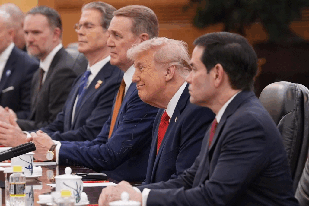 Donald Trump sentado junto a su delegación durante las conversaciones bilaterales en el Gran Salón del Pueblo de Pekín