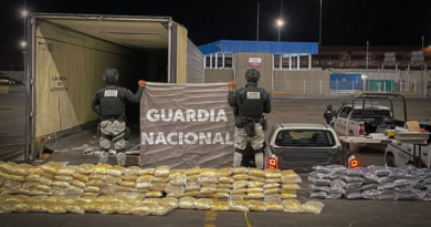 Elementos de la Guardia Nacional resguardan paquetes de droga decomisados junto a un tráiler durante un operativo nocturno.
