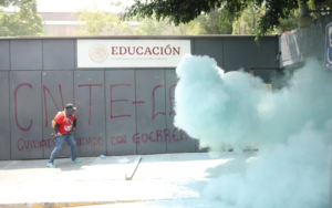 Integrante de la CNTE participa en una protesta frente a instalaciones educativas en Ciudad de México durante las movilizaciones magisteriales de junio de 2026.