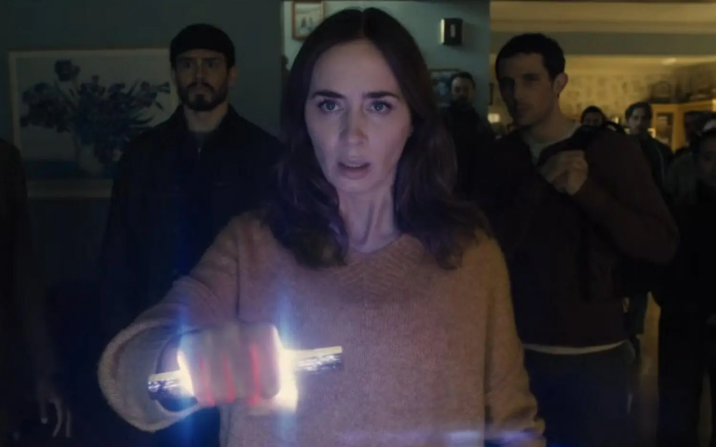 Emily Blunt sostiene un objeto luminoso en una escena oscura de El día de la revelación