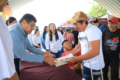 Autoridad estatal entrega documentos de apoyo a un beneficiario durante jornada social en Paraíso.