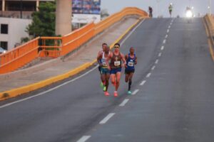 Corredores del Medio Maratón de Villahermosa avanzan por un puente urbano durante la prueba de 21 kilómetros.