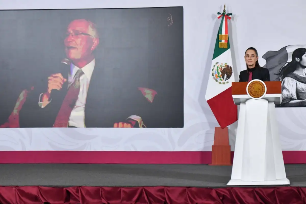 La presidenta Claudia Sheinbaum durante una conferencia en la que aparece proyectada una imagen del empresario Ricardo Salinas Pliego.