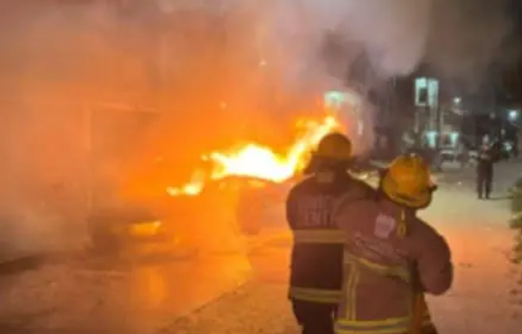 Bomberos atienden un vehículo envuelto en llamas durante la jornada de violencia registrada en Villahermosa.