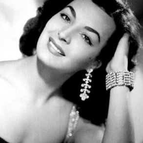 Elsa Aguirre, actriz mexicana de la Época de Oro, en retrato de estudio sonriendo con joyería de la época