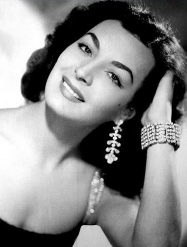Elsa Aguirre, actriz mexicana de la Época de Oro, en retrato de estudio sonriendo con joyería de la época