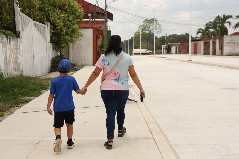 Una mujer y un niño caminan por la nueva calle de concreto hidráulico en Estación Chontalpa
