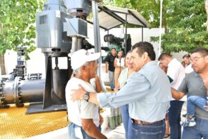 Javier May saluda a un vecino junto al equipo rehabilitado del cárcamo de bombeo de la colonia Belén