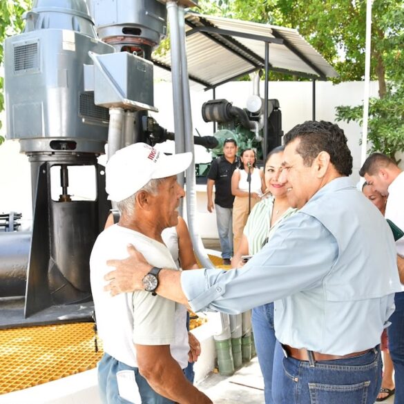 Javier May saluda a un vecino junto al equipo rehabilitado del cárcamo de bombeo de la colonia Belén
