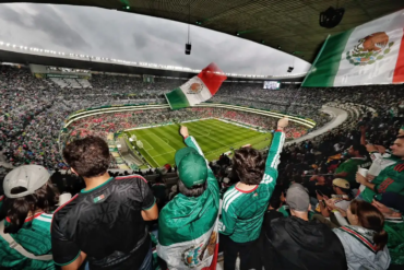 Aficionados mexicanos ondean banderas en el estadio Azteca durante el partido México-Inglaterra.