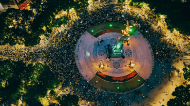 Vista aérea nocturna del Ángel de la Independencia rodeado por una multitud que celebra el pase de México a octavos de final del Mundial 2026