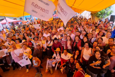 Militantes de Morena participan en una asamblea informativa con banderas y carteles sobre soberanía nacional.