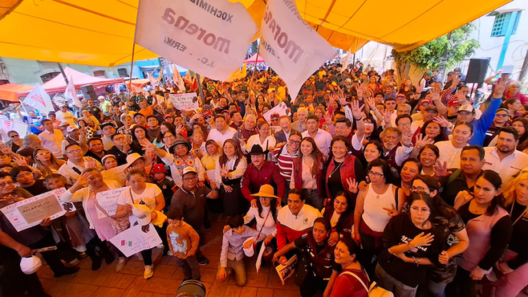 Militantes de Morena participan en una asamblea informativa con banderas y carteles sobre soberanía nacional.
