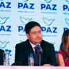 Dirigentes de Partido PAZ durante una conferencia con el logotipo del nuevo instituto político al fondo.