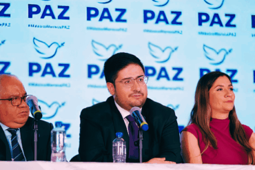 Dirigentes de Partido PAZ durante una conferencia con el logotipo del nuevo instituto político al fondo.