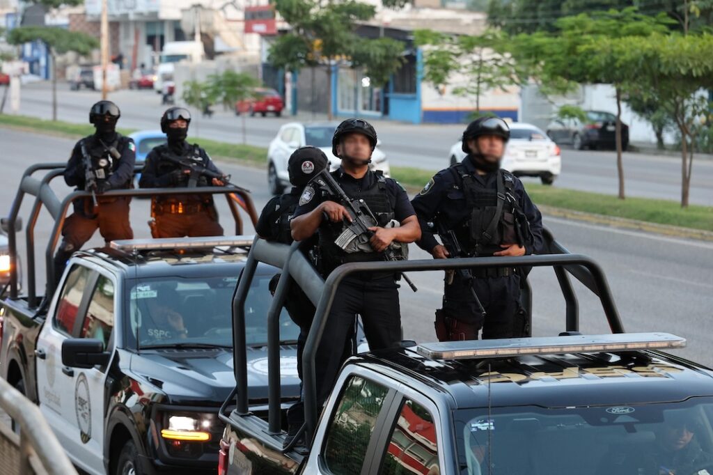 Policías con equipo táctico y armas largas resguardan una vialidad durante un operativo de seguridad en Tabasco
