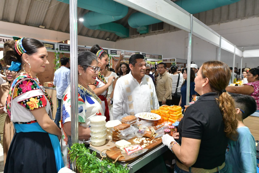 El gobernador Javier May y la presidenta de Balancán, posan junto a un puesto de quesos y embutidos en el Festival del Queso de Poro de Balancán
