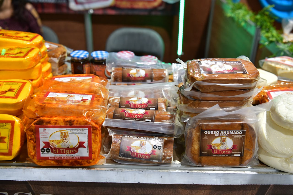 Piezas de queso de poro y queso ahumado exhibidas por productores en el festival de Balancán