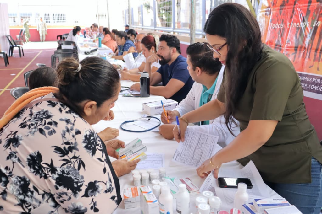 Personal de salud entrega medicamentos y atiende a una mujer durante una jornada comunitaria en Huimanguillo