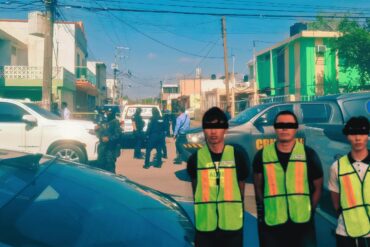 Tres personas detenidas con chalecos de identificación son presentadas por autoridades de Tabasco, con peritos y vehículos oficiales al fondo