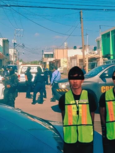 Tres personas detenidas con chalecos de identificación son presentadas por autoridades de Tabasco, con peritos y vehículos oficiales al fondo