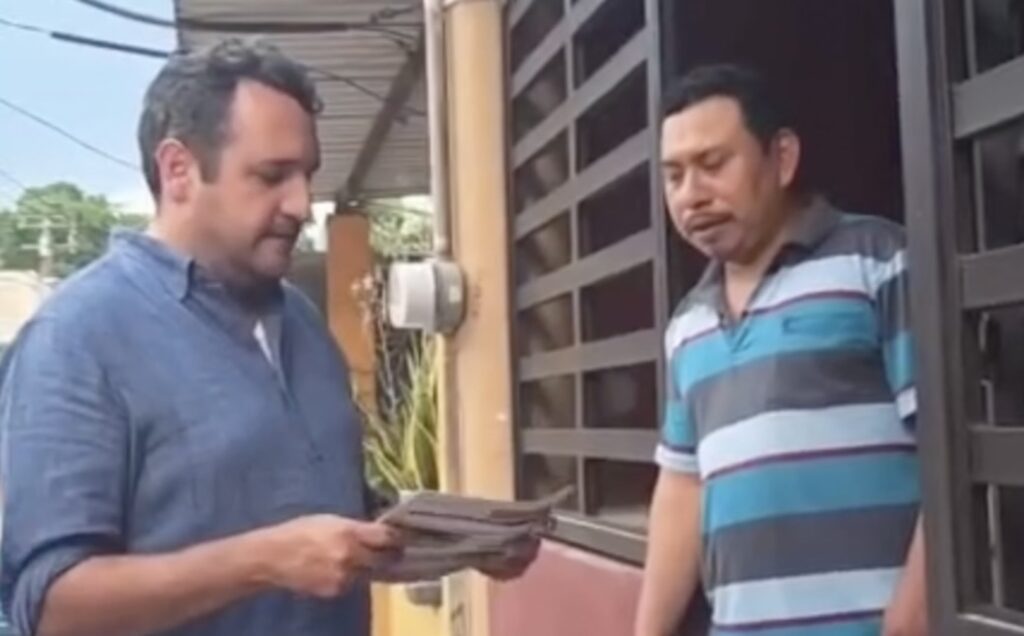 Andrés Manuel López Beltrán entrega documentos a un habitante durante su recorrido casa por casa en Tabasco