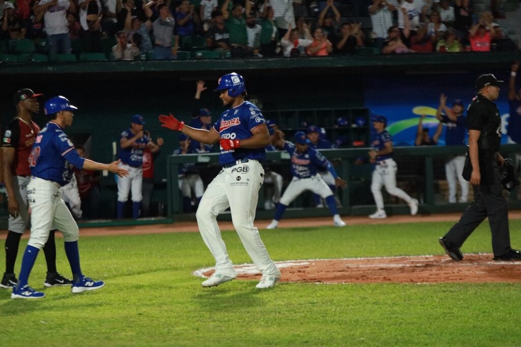 ugador de Olmecas de Tabasco celebra tras cruzar el plato y anotar carrera.