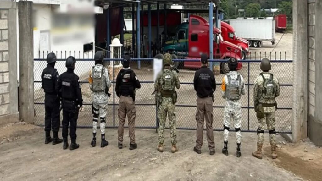 Elementos de seguridad estatal y militar resguardan la entrada de un predio con tráileres asegurados en un operativo contra el huachicol en Tabasco