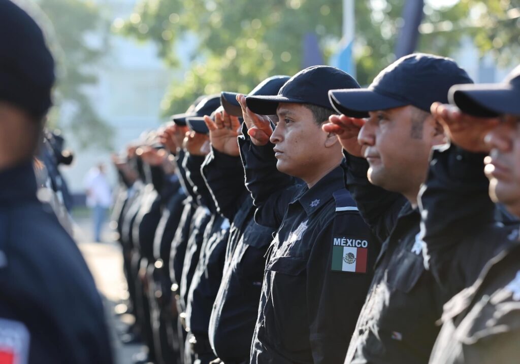 Egresados de la Universidad de la Policía de Ciudad de México lanzan sus birretes durante una ceremonia