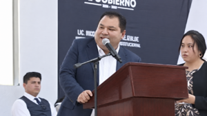 Presidente municipal de Nicolás Flores, Hidalgo, habla desde un podio durante un acto público.