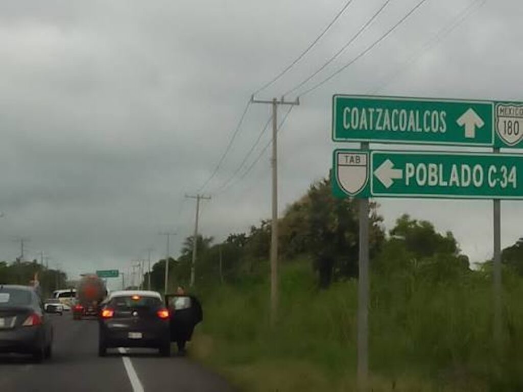 Camiones y maquinaria pesada en una operación minera a cielo abierto rodeada de vegetación