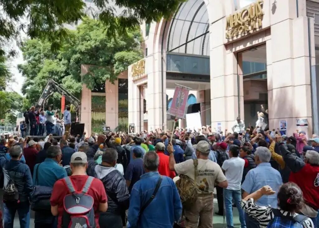 Multitud de electricistas con el puño en alto frente a la entrada del Hotel Marquis Reforma