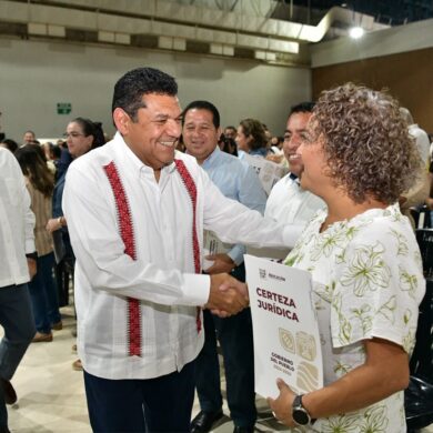 Directora escolar recibe documento de certeza jurídica durante la entrega de escrituras a escuelas en Villahermosa