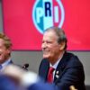 Vicente Fox sonríe durante su visita a la sede nacional del PRI, con el logotipo del partido de fondo
