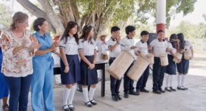 Lorena Méndez Denis entrega instrumentos para formar un grupo de tamborileros en una telesecundaria de Comalcalco