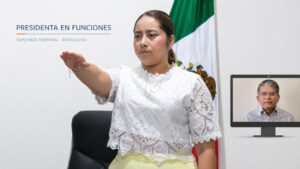 María Eliza Hernández Flores rinde protesta en primer plano, mientras Alfonso Baca aparece en una pantalla por su licencia temporal.