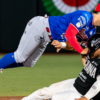 Jugador de Toros de Tijuana levanta los brazos mientras un pelotero de Olmecas aparece en primer plano.