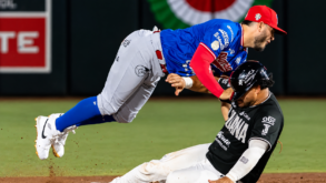 Jugador de Toros de Tijuana levanta los brazos mientras un pelotero de Olmecas aparece en primer plano.