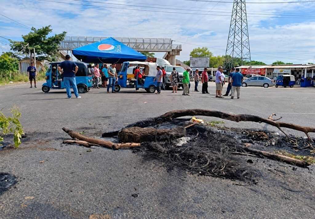 Restos de la barricada y mototaxistas congregados en el punto de bloqueo de Tamulté de las Sabanas
